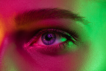 Image showing Close up portrait of female fashion model in neon light on dark studio background.