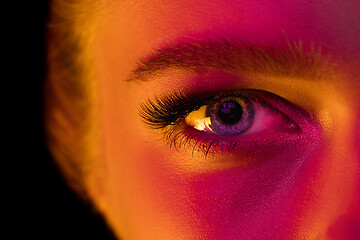 Image showing Close up portrait of female fashion model in neon light on dark studio background.