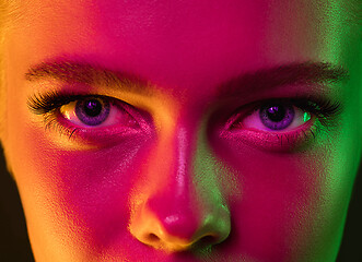 Image showing Close up portrait of female fashion model in neon light on dark studio background.