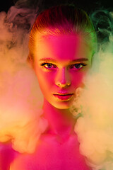 Image showing Portrait of female fashion model in neon light on dark studio background.