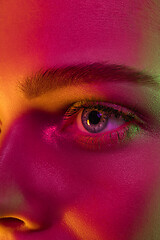 Image showing Close up portrait of female fashion model in neon light on dark studio background.