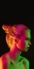 Image showing Portrait of female fashion model in neon light on dark studio background.