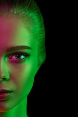 Image showing Portrait of female fashion model in neon light on dark studio background.