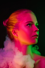 Image showing Portrait of female fashion model in neon light on dark studio background.