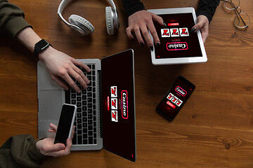 Image showing Close up laptop and smartphone screen with mobile app for online casino lottery