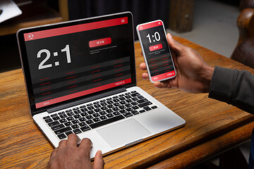 Image showing Close up laptop and smartphone screen with mobile app for betting and score