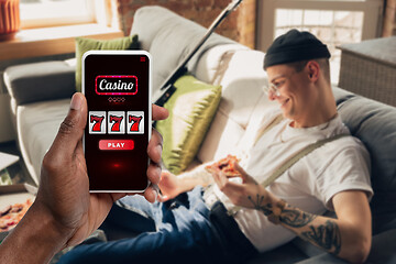 Image showing Device screen with mobile app for online casino lottery, cheering man, winner on background