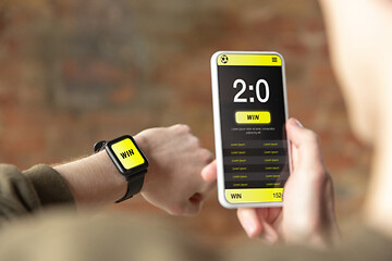 Image showing Close up watch and smartphone screen with mobile app for betting and score