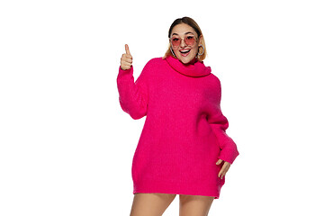 Image showing Beautiful young woman in bright pink comfortable sweater, long sleeve isolated on white studio background