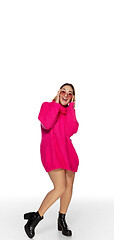 Image showing Beautiful young woman in bright pink comfortable sweater, long sleeve isolated on white studio background