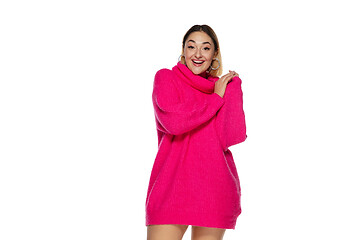 Image showing Beautiful young woman in bright pink comfortable sweater, long sleeve isolated on white studio background