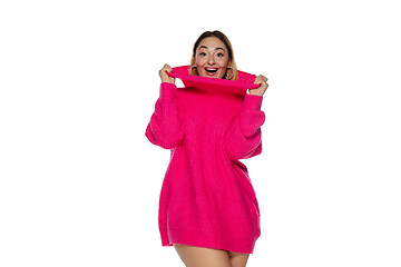 Image showing Beautiful young woman in bright pink comfortable sweater, long sleeve isolated on white studio background