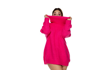 Image showing Beautiful young woman in bright pink comfortable sweater, long sleeve isolated on white studio background