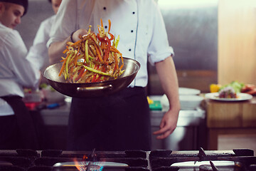 Image showing chef flipping vegetables in wok