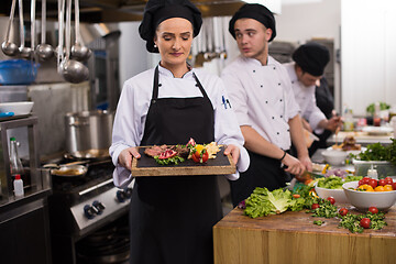 Image showing female Chef holding beef steak plate