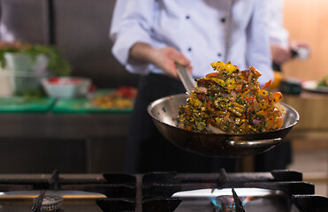 Image showing chef flipping vegetables in wok