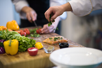 Image showing Chef hands preparing marinated Salmon fish