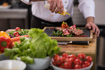 Image showing Chef finishing steak meat plate