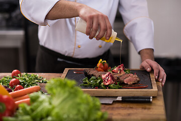 Image showing Chef finishing steak meat plate