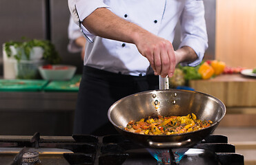 Image showing chef putting spices on vegetables in wok