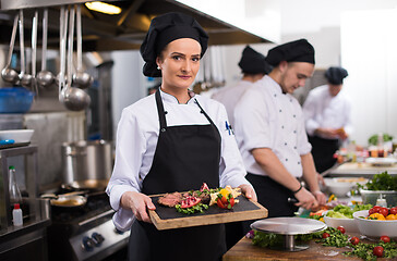 Image showing female Chef holding beef steak plate