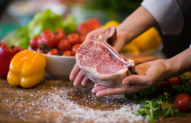 Image showing Chef holding juicy slice of raw steak