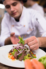 Image showing cook chef decorating garnishing prepared meal