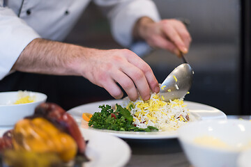 Image showing Chef hands serving vegetable risotto