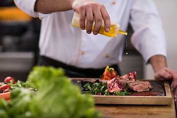 Image showing Chef finishing steak meat plate