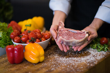 Image showing Chef holding juicy slice of raw steak