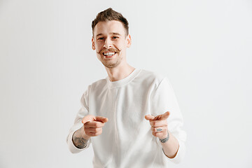 Image showing The happy businessman standing and smiling against gray background.