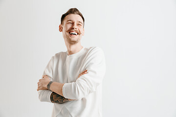 Image showing The happy businessman standing and smiling against gray background.