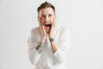 Image showing The young emotional angry man screaming on garay studio background