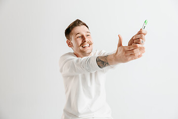 Image showing Happy man looking at pregnancy test at studio