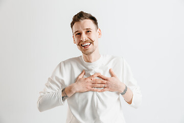 Image showing The happy businessman standing and smiling against gray background.