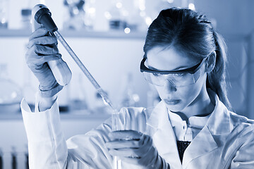 Image showing Young scientist pipetting in life science laboratory.