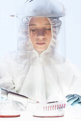 Image showing Female scientist working in the corona virus vaccine development laboratory research with a highest degree of protection gear.