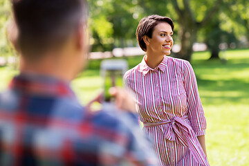 Image showing couple photographing by smartphone in park