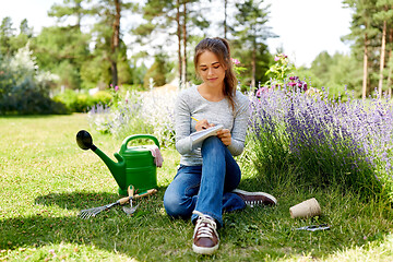 Image showing young woman writing to notebook at summer garden