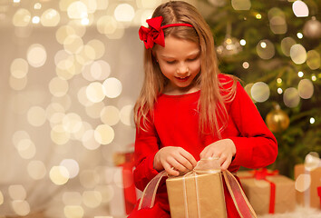 Image showing smiling girl with christmas gift at home