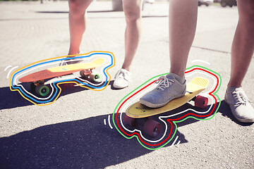 Image showing teenage couple riding skateboards on city street