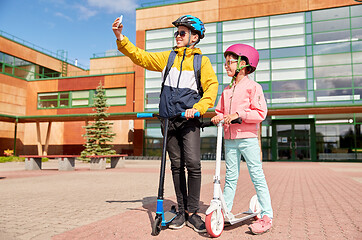 Image showing happy school kids with scooters taking selfie