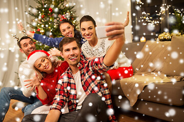 Image showing friends celebrating christmas and taking selfie