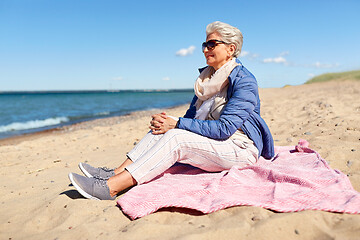 Image showing happy senior woman in jacket on beach