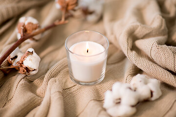 Image showing burning candle and cotton flower on blanket