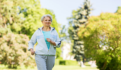 Image showing senior woman running along summer park