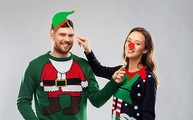 Image showing couple with christmas party props in ugly sweaters