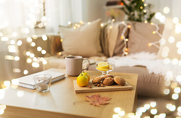 Image showing oat cookies, book, tea and lemon on table at home