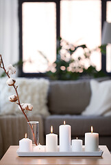 Image showing burning white candles on table at cozy home