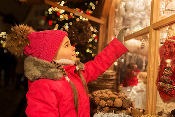 Image showing girl choosing christmas decorations at market